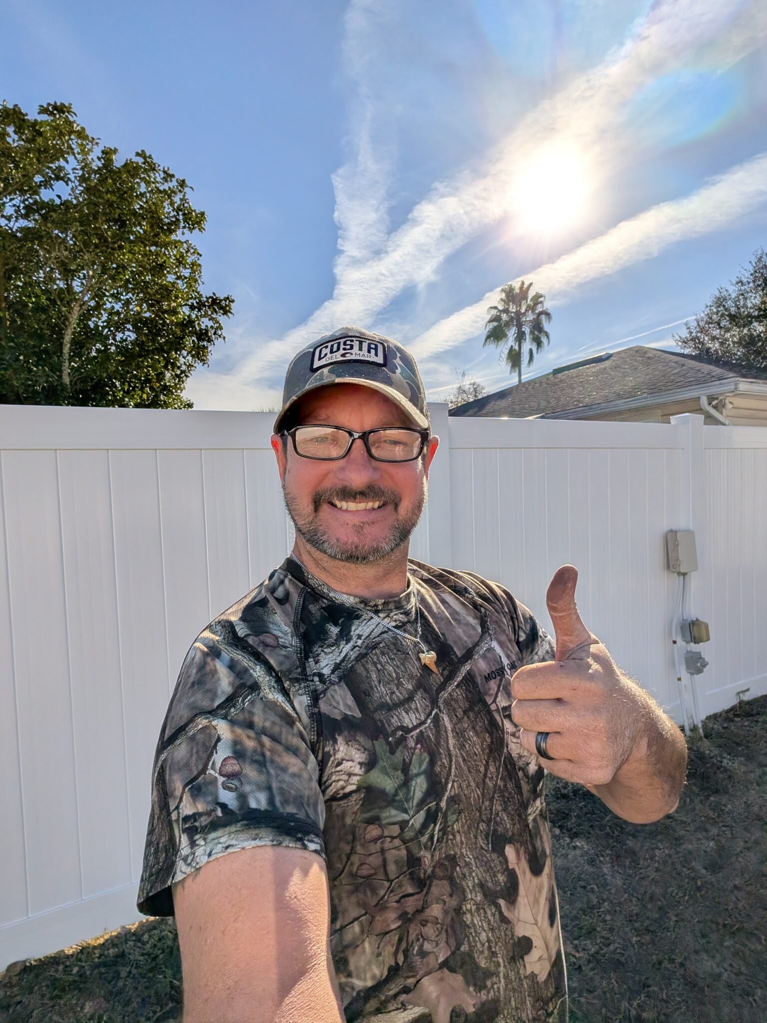Tommy Cantrell beside a newly installed white vinyl fence