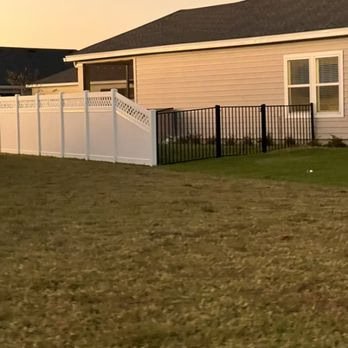 Black aluminum fencing beside white vinyl fencing