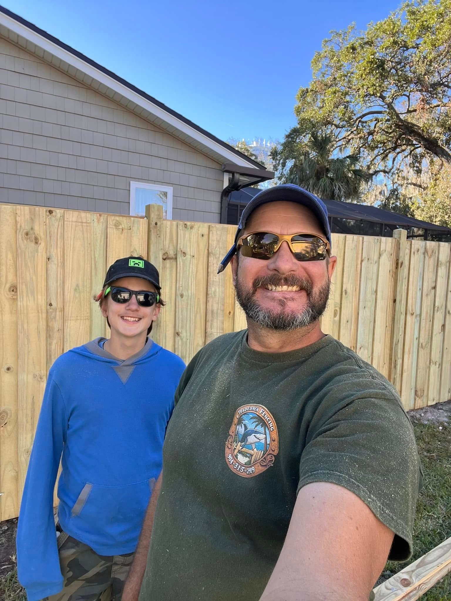 Tommy and Deeds in front of a wood fence project