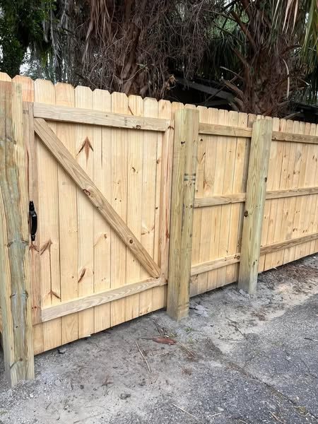 Closed wood privacy fence gate with visible diagonal bracing
