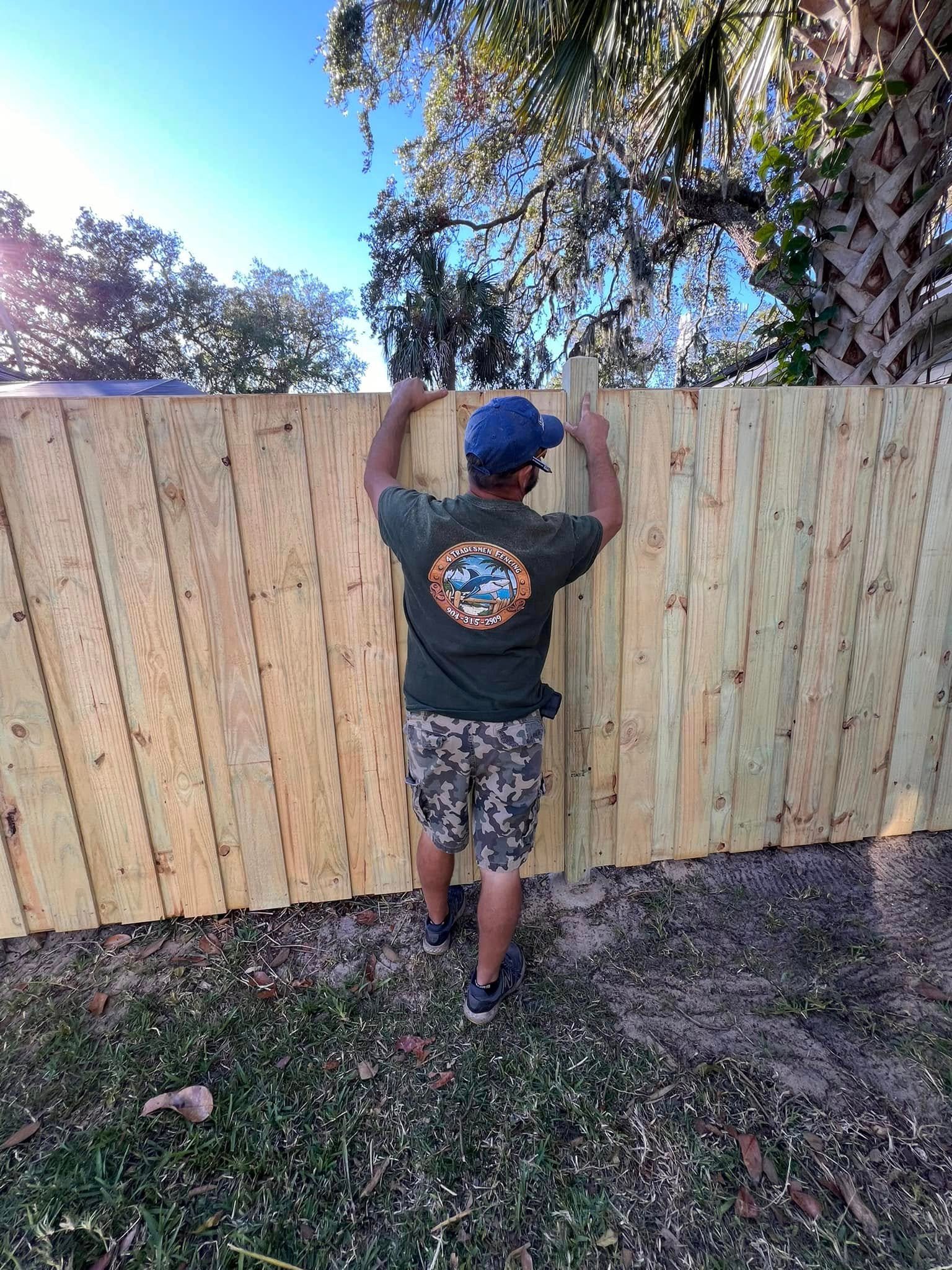 Tommy beside a six-foot wood fence built by 4 Tradesmen Fencing