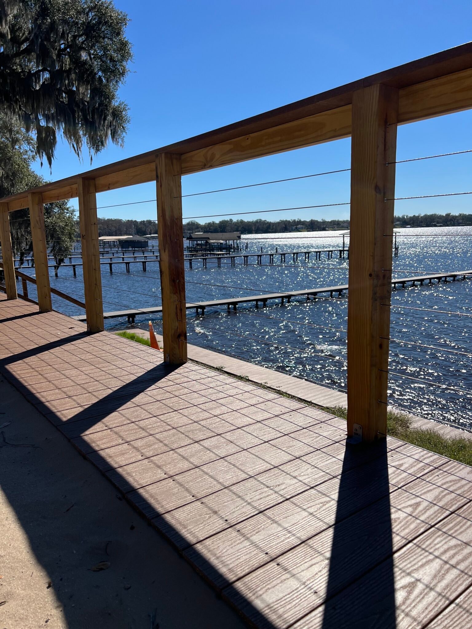 Horizontal cable railing between wood posts on a waterfront deck